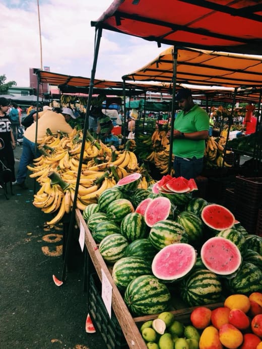 An outdoor market stall with fruits.